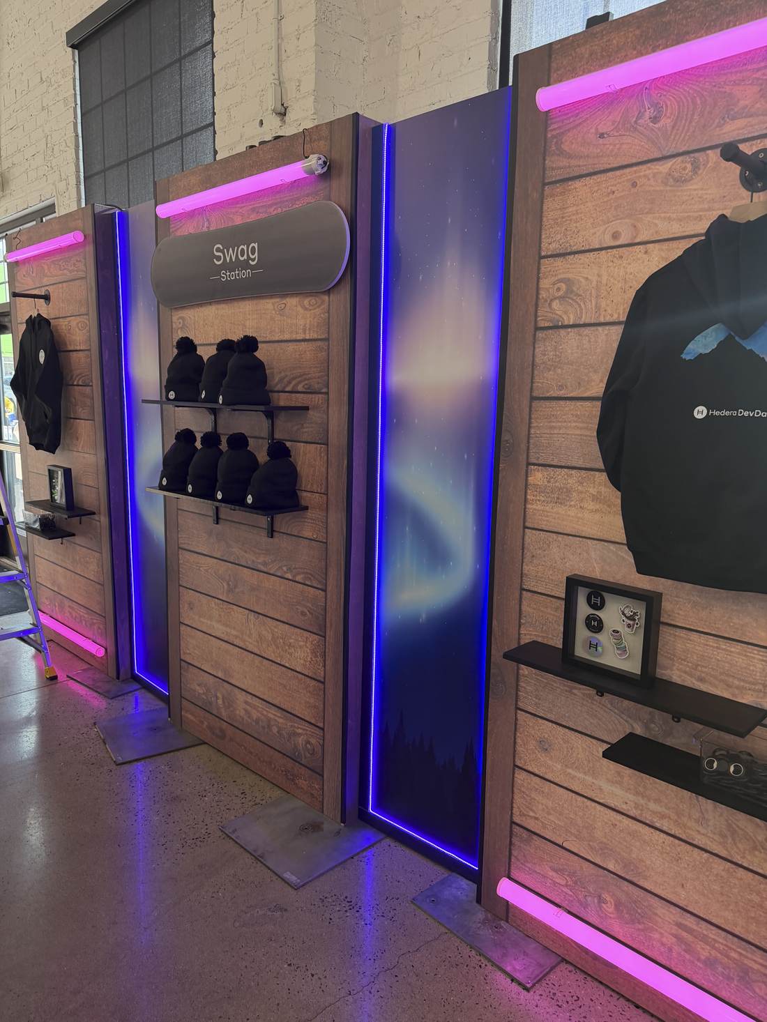 Swag station display wall with hoodies and beanies