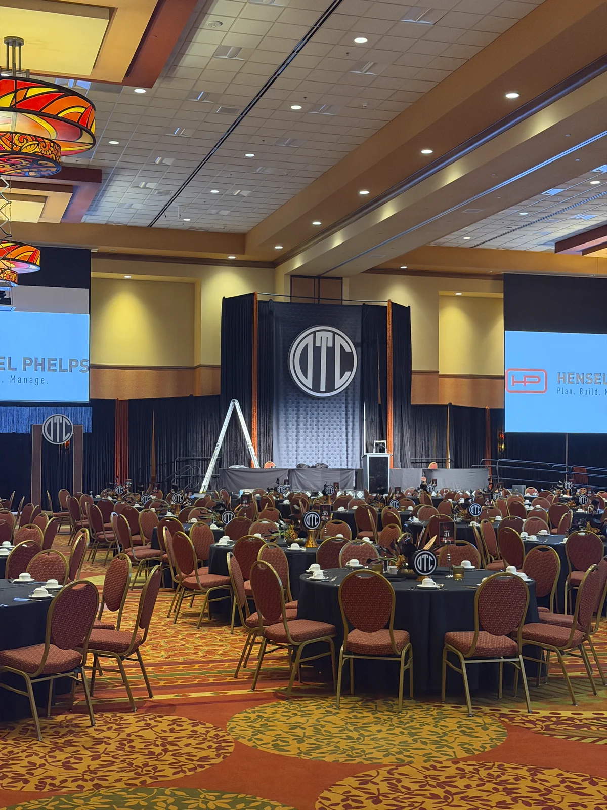 The ballroom from the side showing the stage, screens, and seated guests