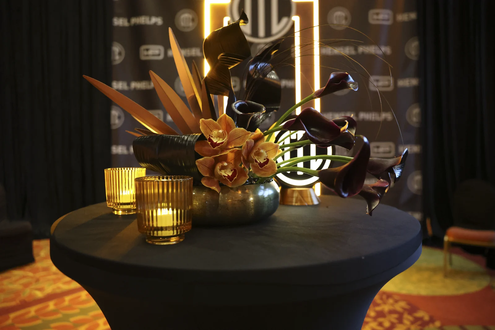 Wide view of the step-and-repeat with florals and the lit OTC arch