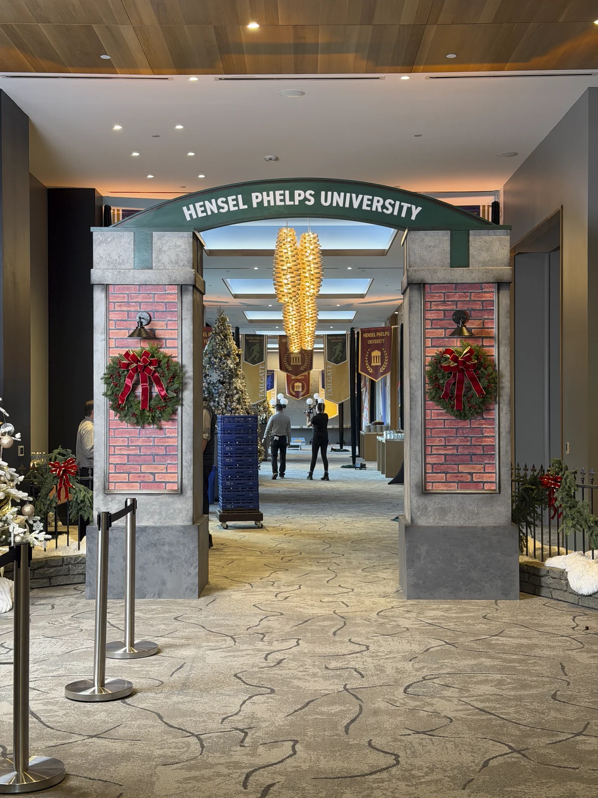 Finished campus archway with brick vinyls, wreaths, and the Hensel Phelps University sign on top