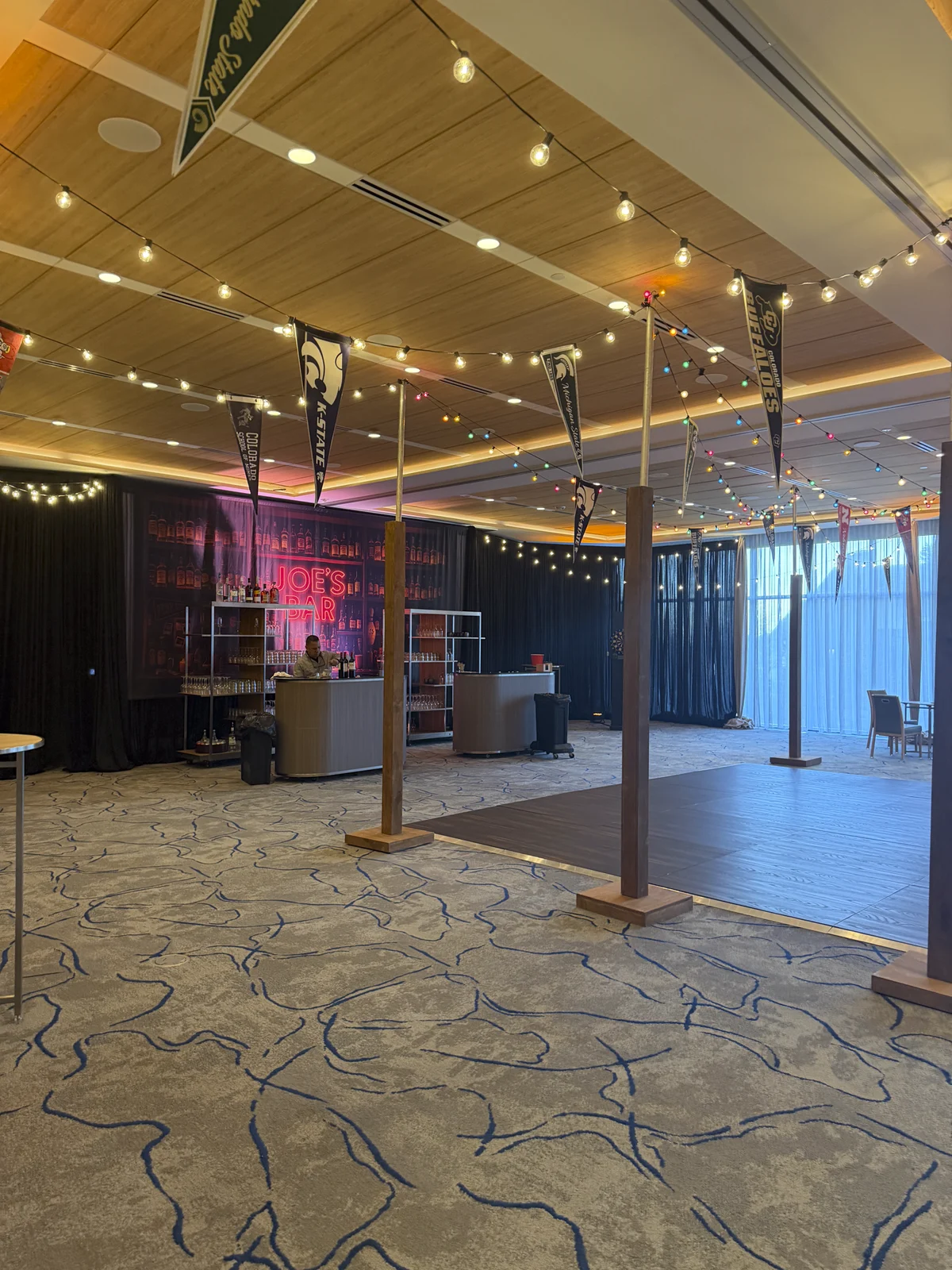 Wide view of the dive bar room with pennants and string lights
