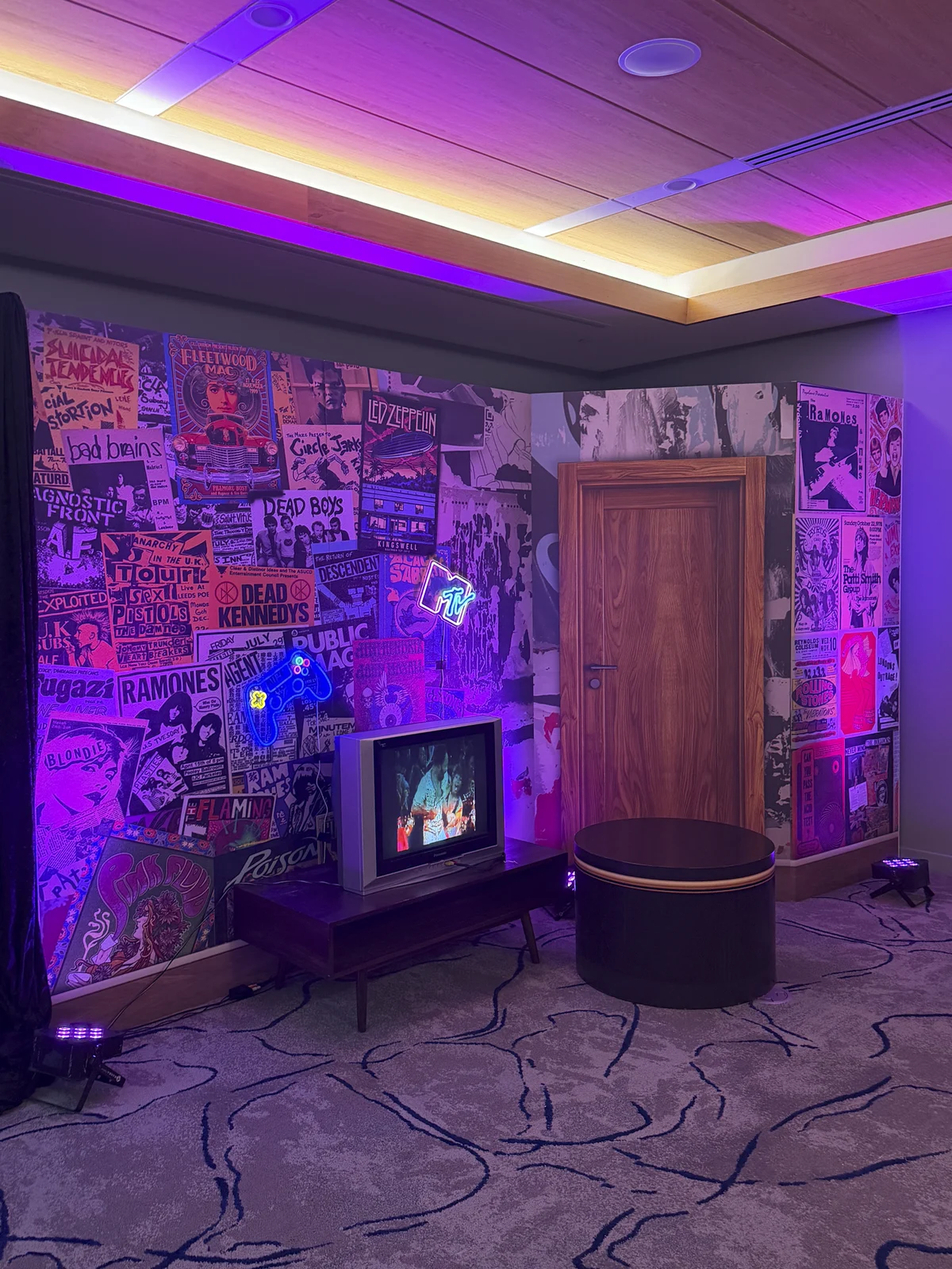 The dorm door and television detail under purple lighting