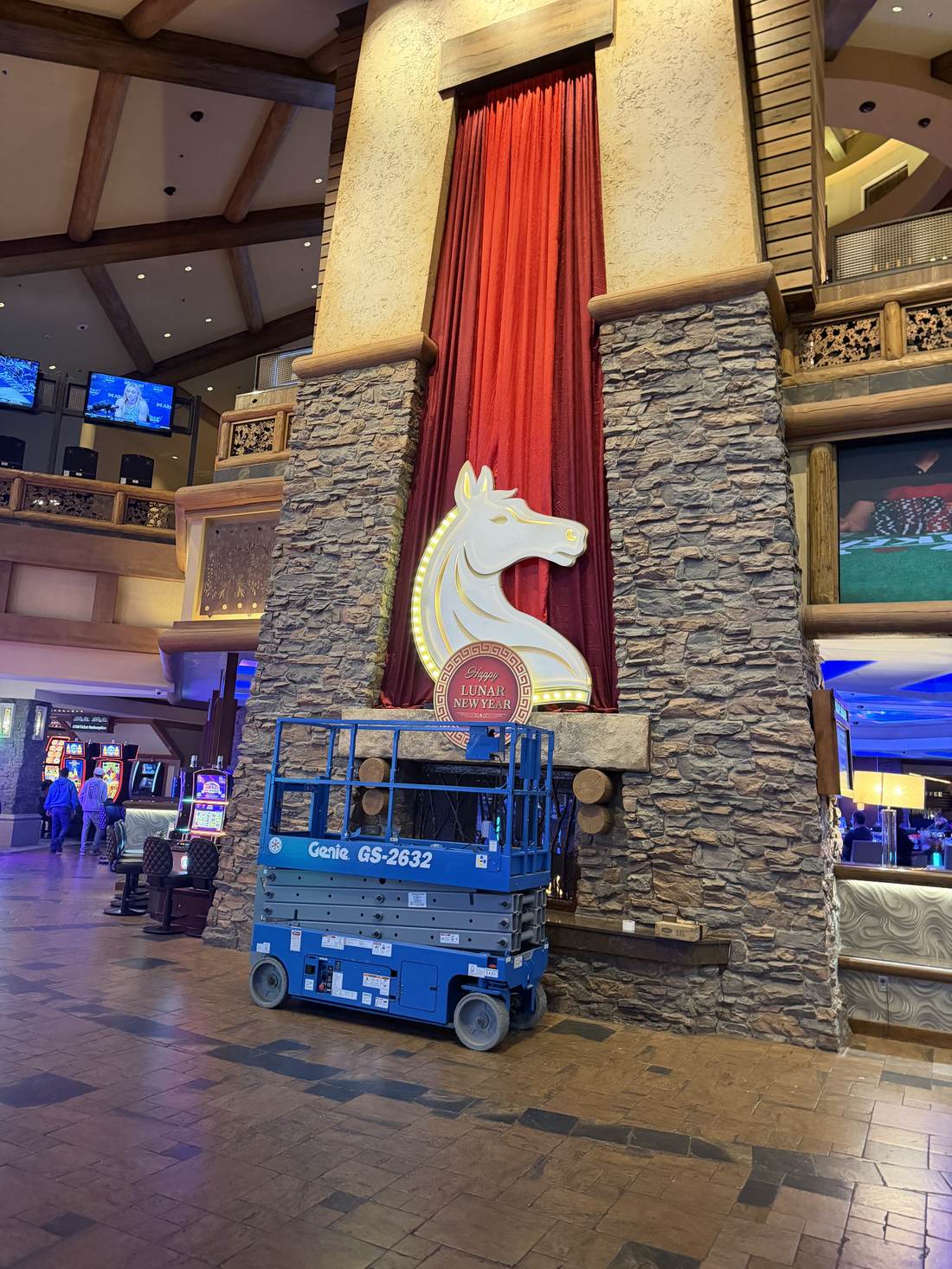 Lit horse-head medallion mounted above the casino fireplace, full atrium view