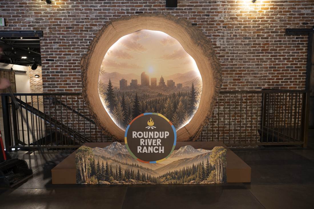 Round entrance backdrop with Denver skyline illustration and Roundup River Ranch logo