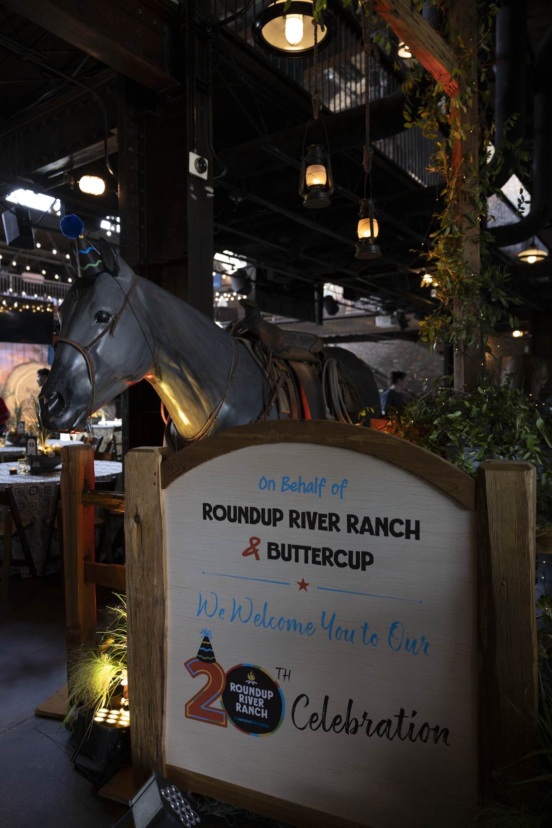 Welcome sign with horse statue and 20th anniversary celebration text