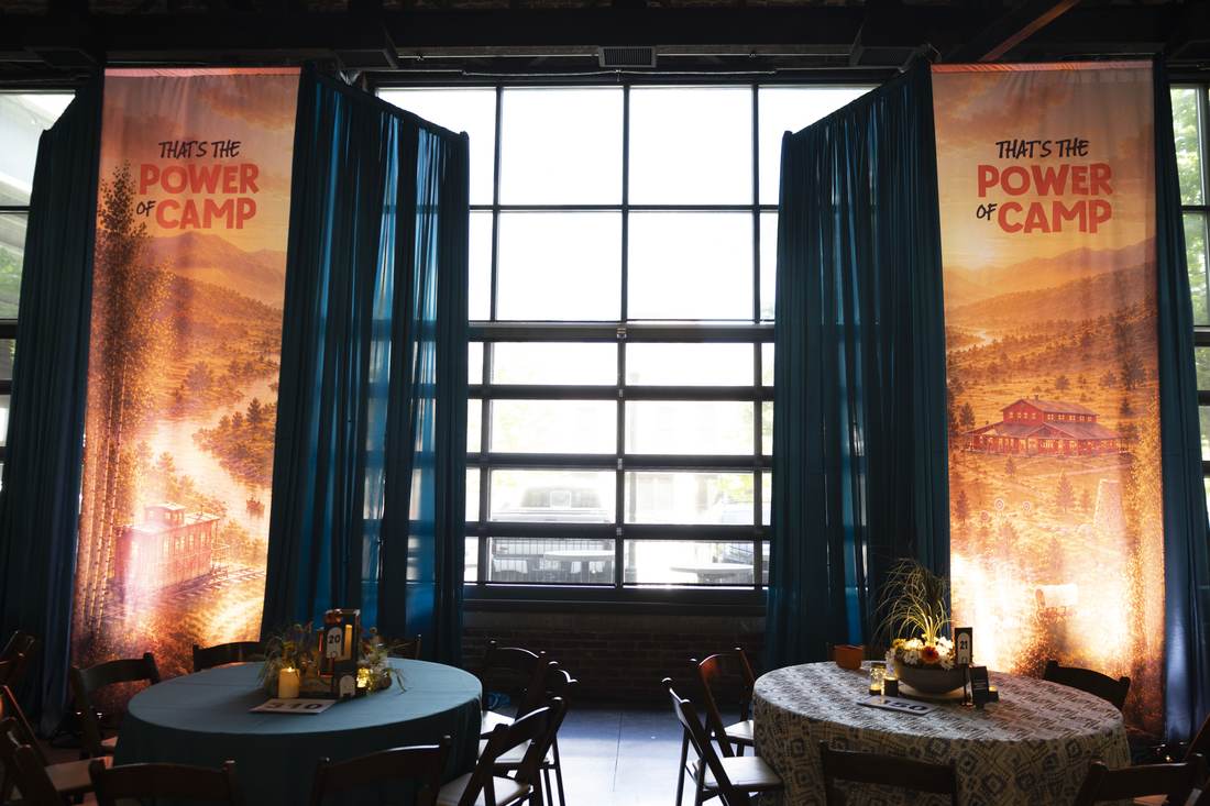 Power of Camp banners flanking the room