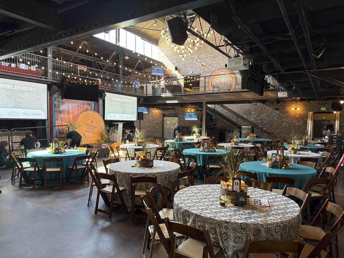 Full room set for the gala with guest tables and stage backdrop