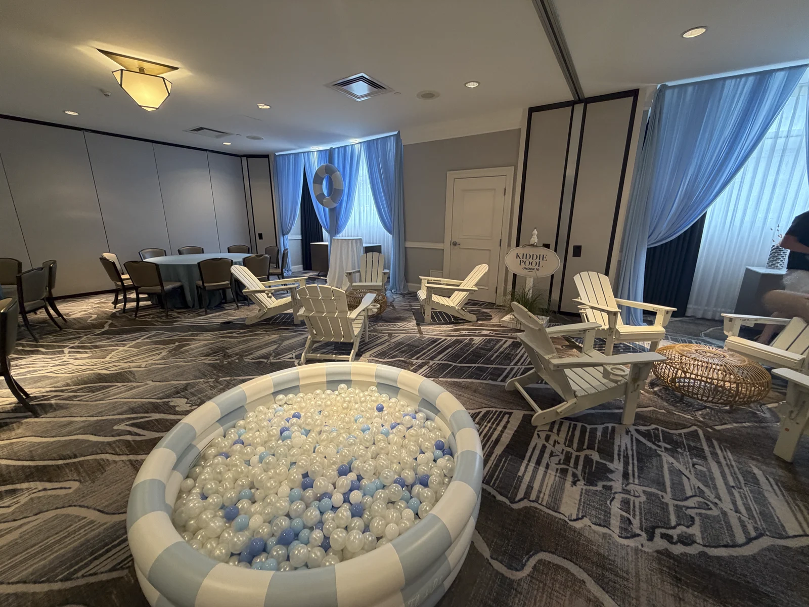 Lounge area with adirondack chairs and a striped ball pit
