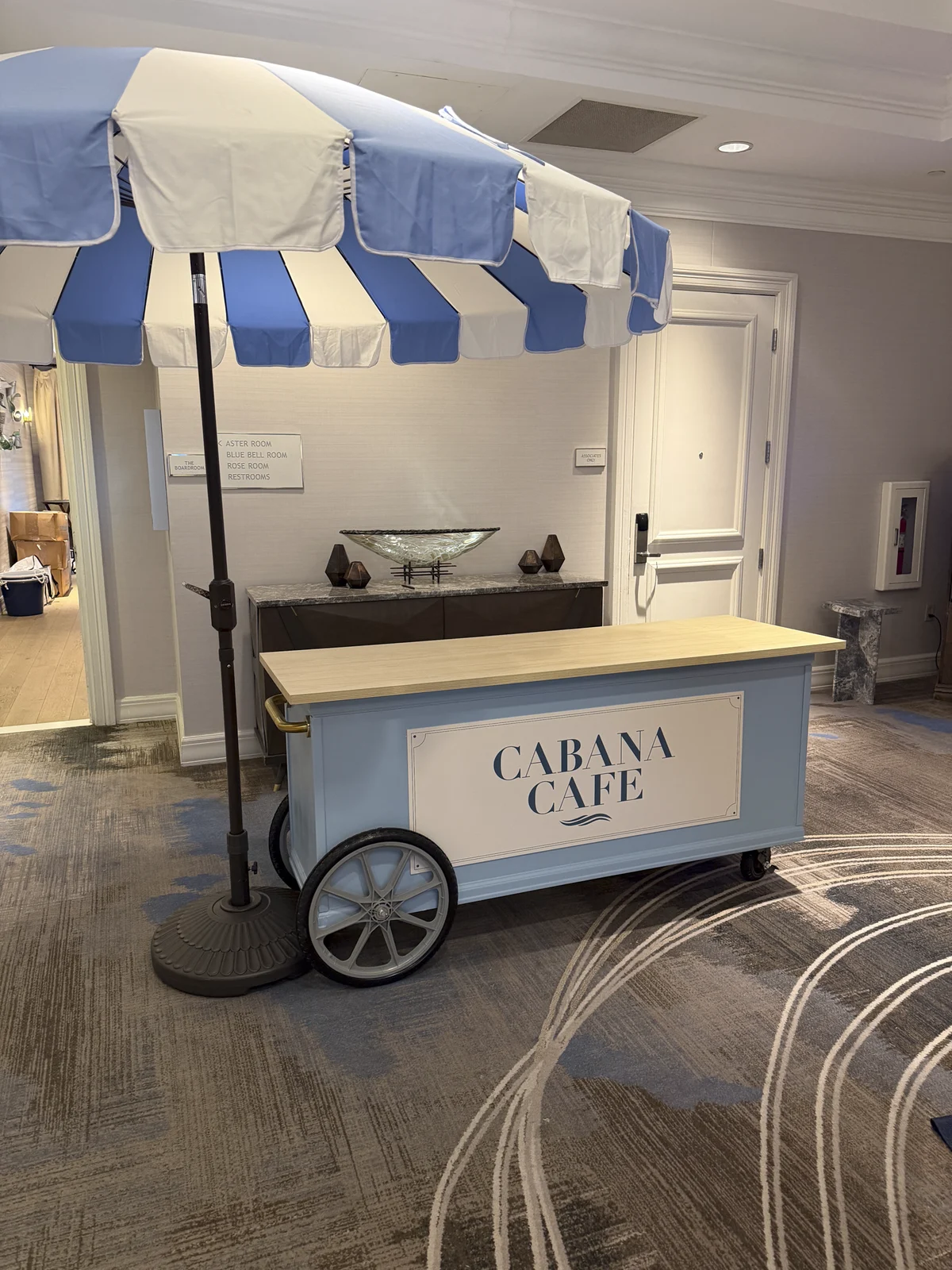 Cabana Cafe cart with a striped umbrella and branded signage