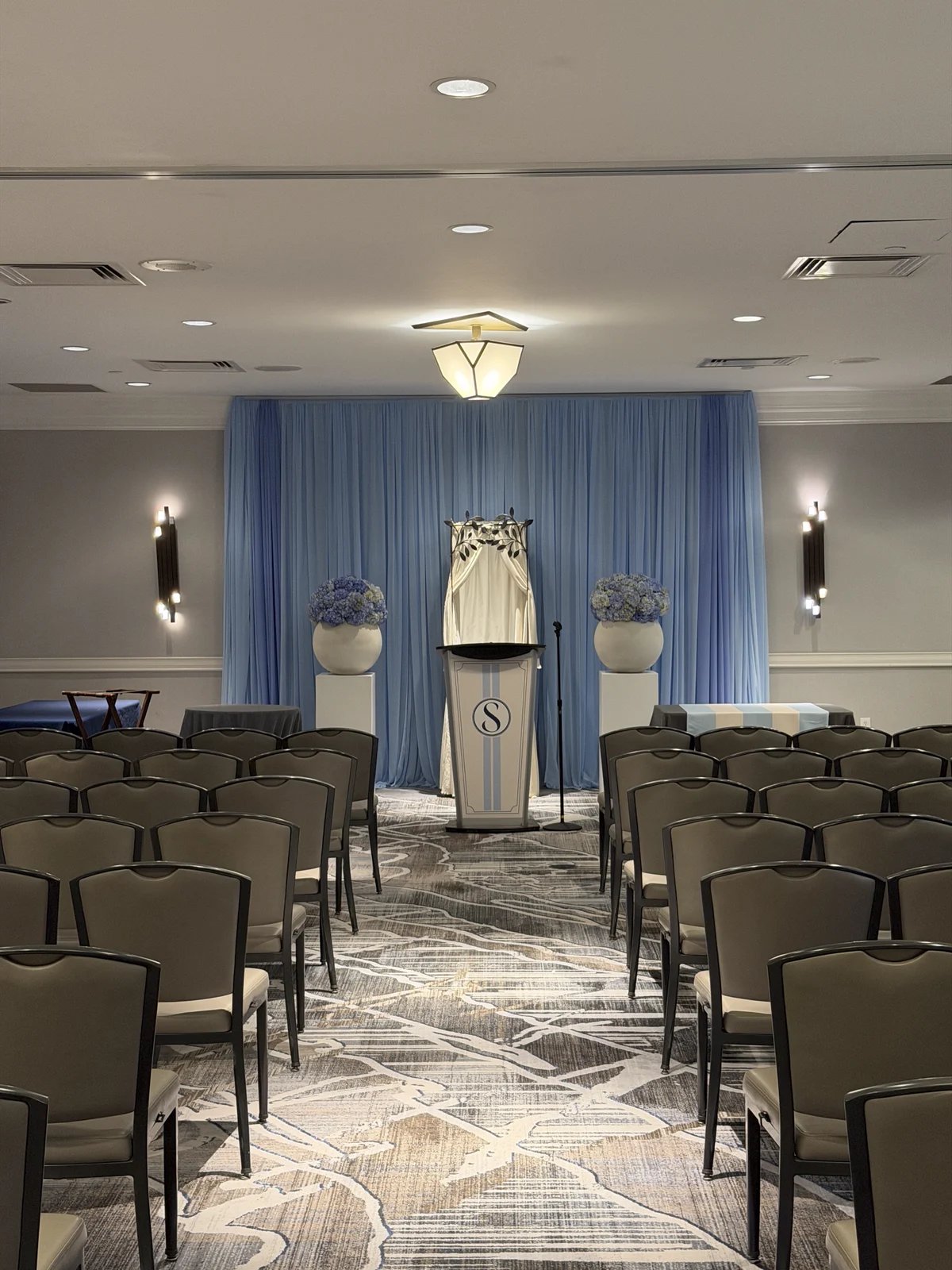 Ceremony podium with the S monogram against blue drapery