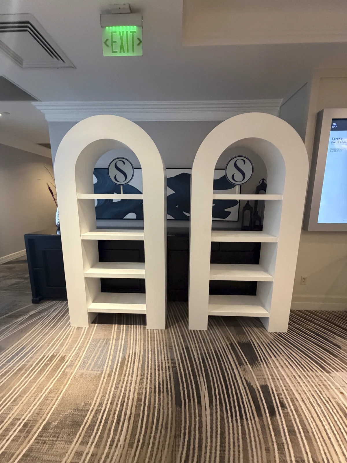 Arched merch display shelves with the S monogram