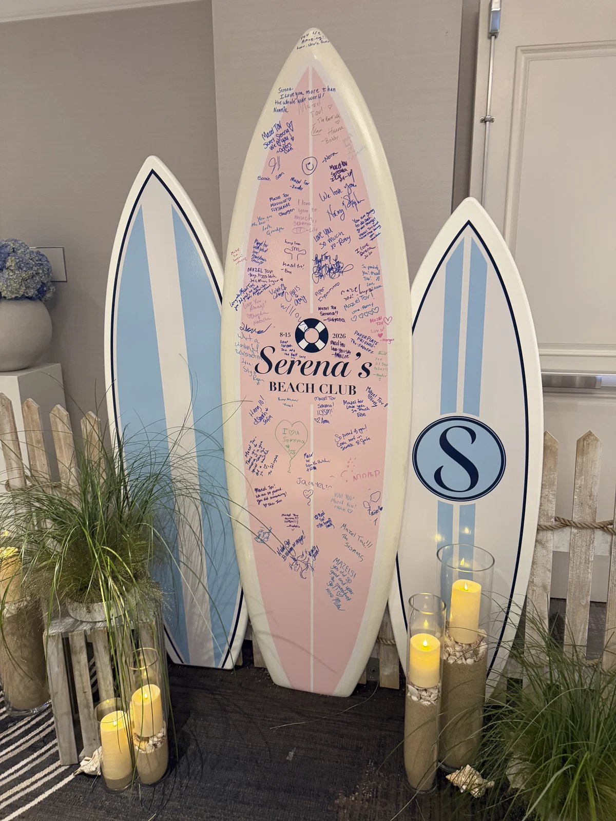 The center surfboard covered in guest signatures at the end of the night