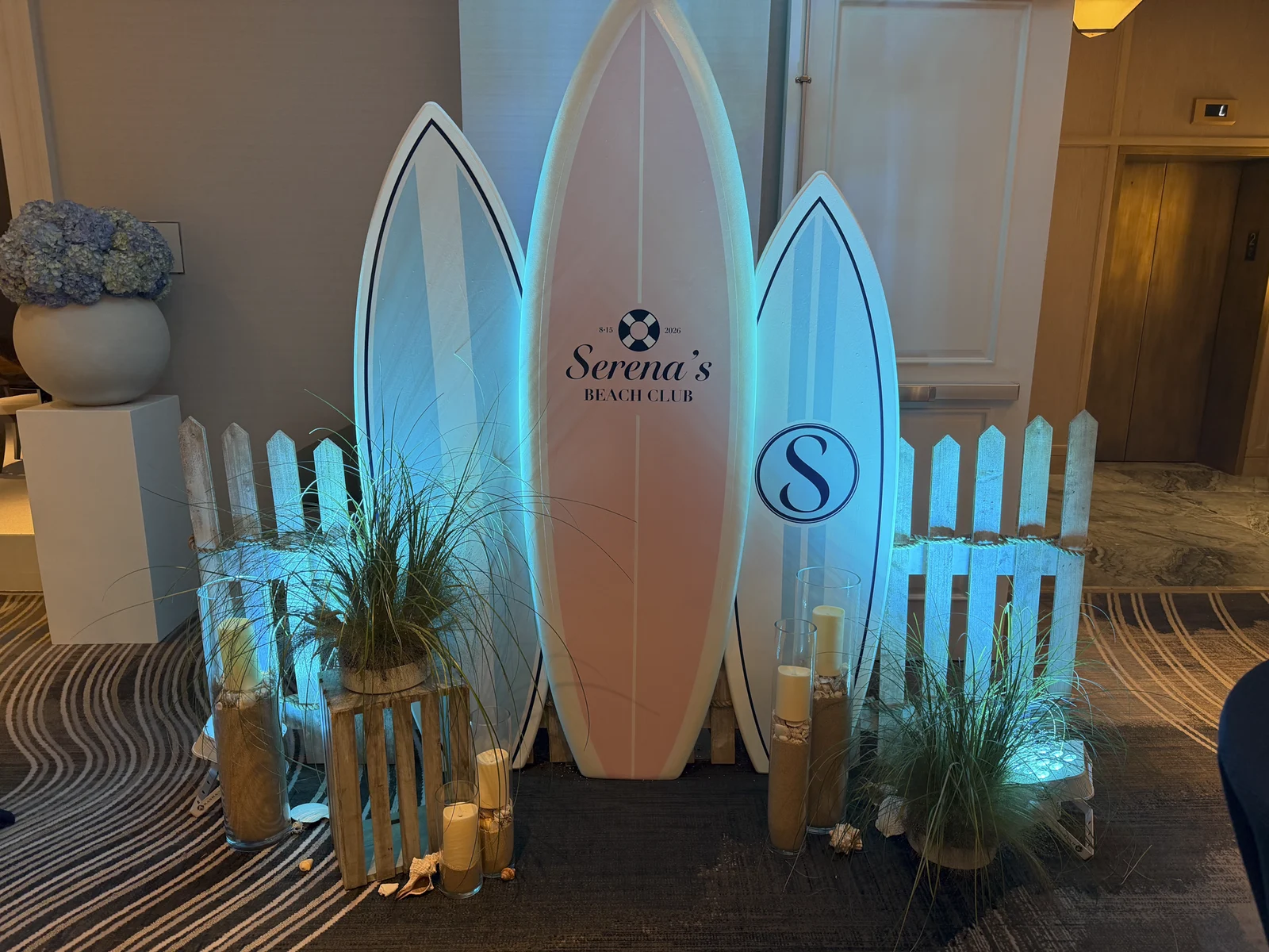 The surfboard signage lit with blue uplighting at night